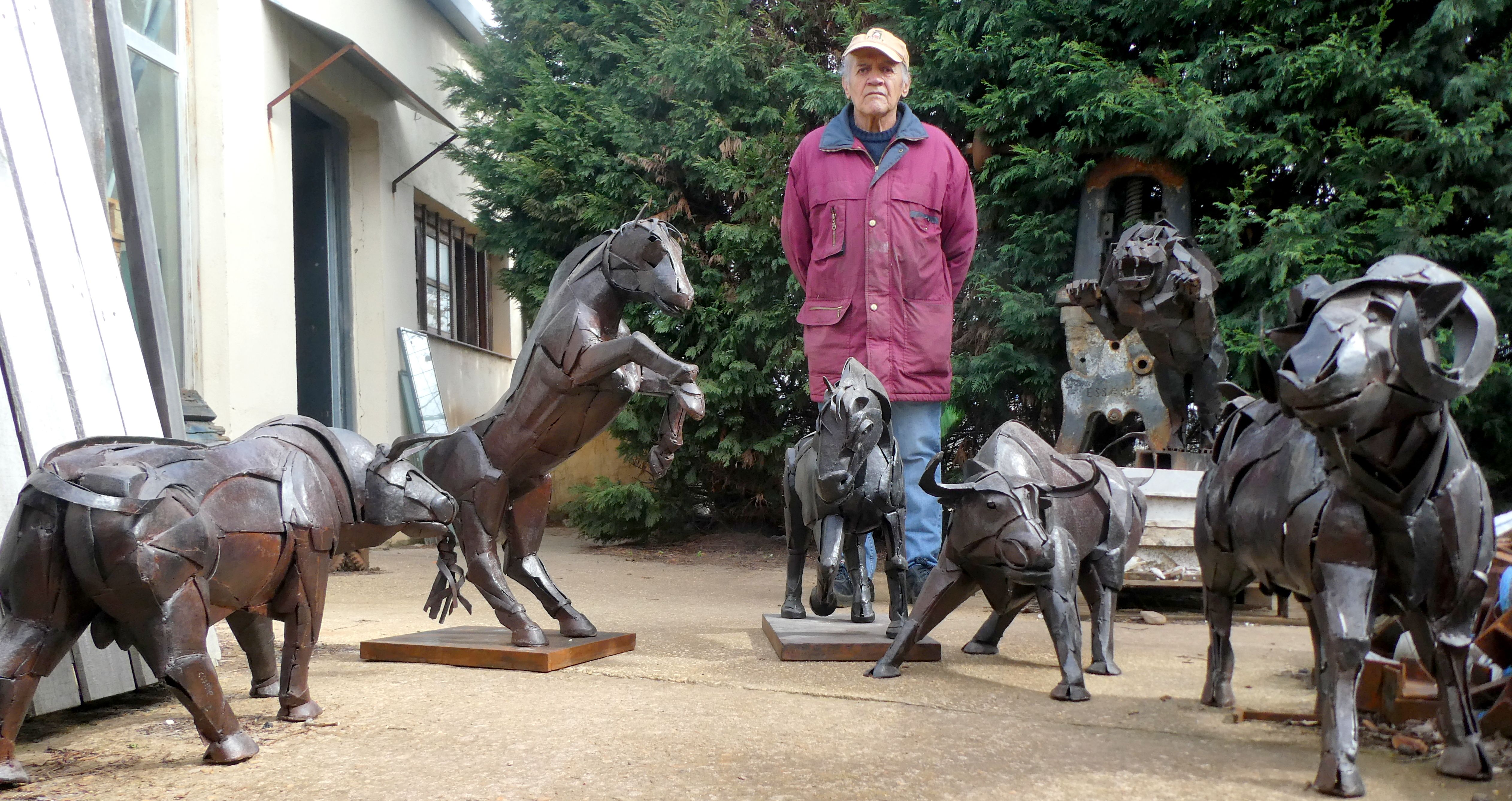 El escultor Cosme Paredes escoltado por su fauna artística. | REPORTAJE GRÁFICO DE GREGORIO FERNÁNDEZ CASTAÑÓN