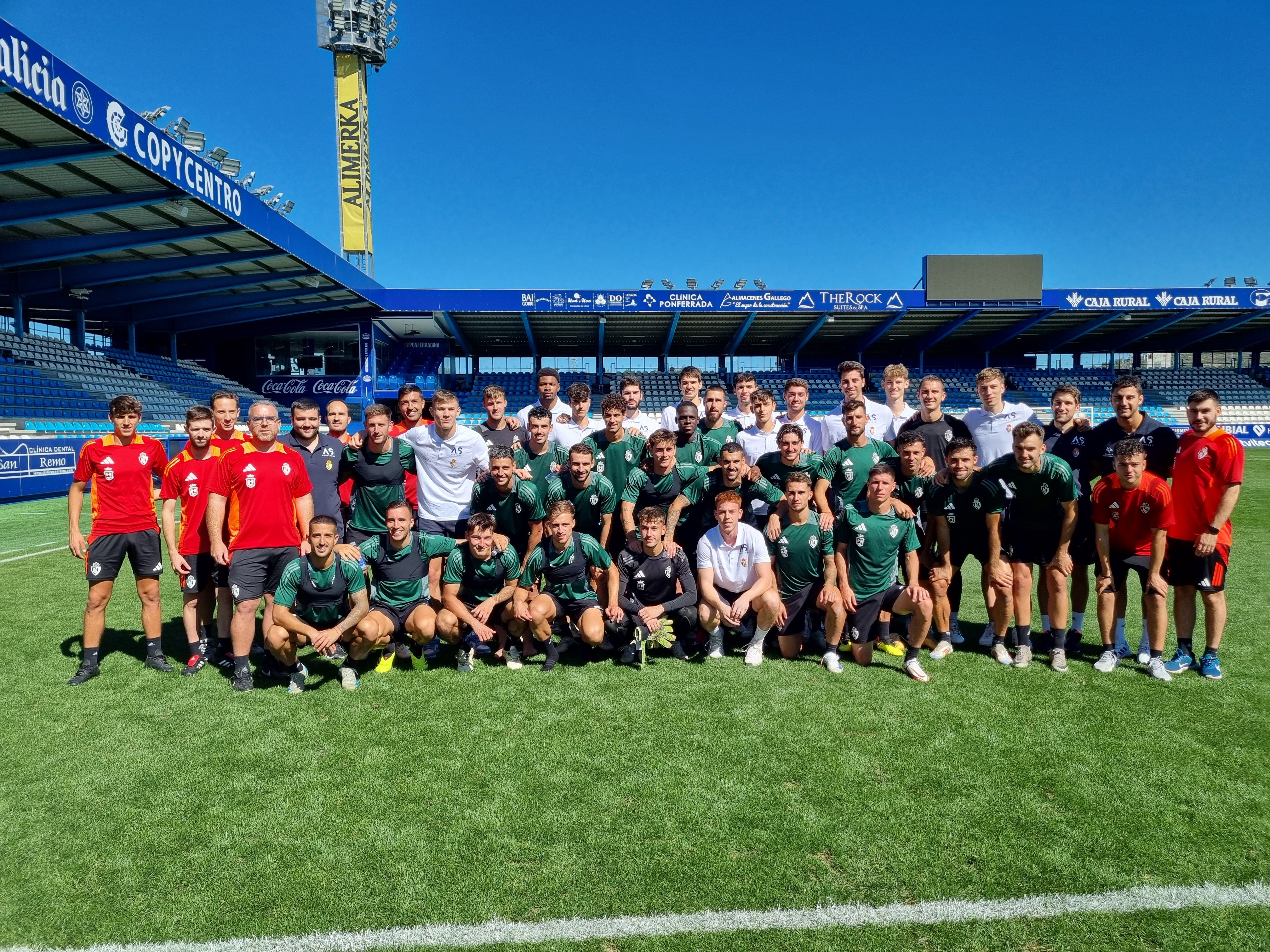 Imagen de las dos plantillas, la de la Deportiva, de verde, y la del Clínica Ponferrada de blanco, más los cuerpos técnicos de ambos equipos. | RAÚL FERNÁNDEZ