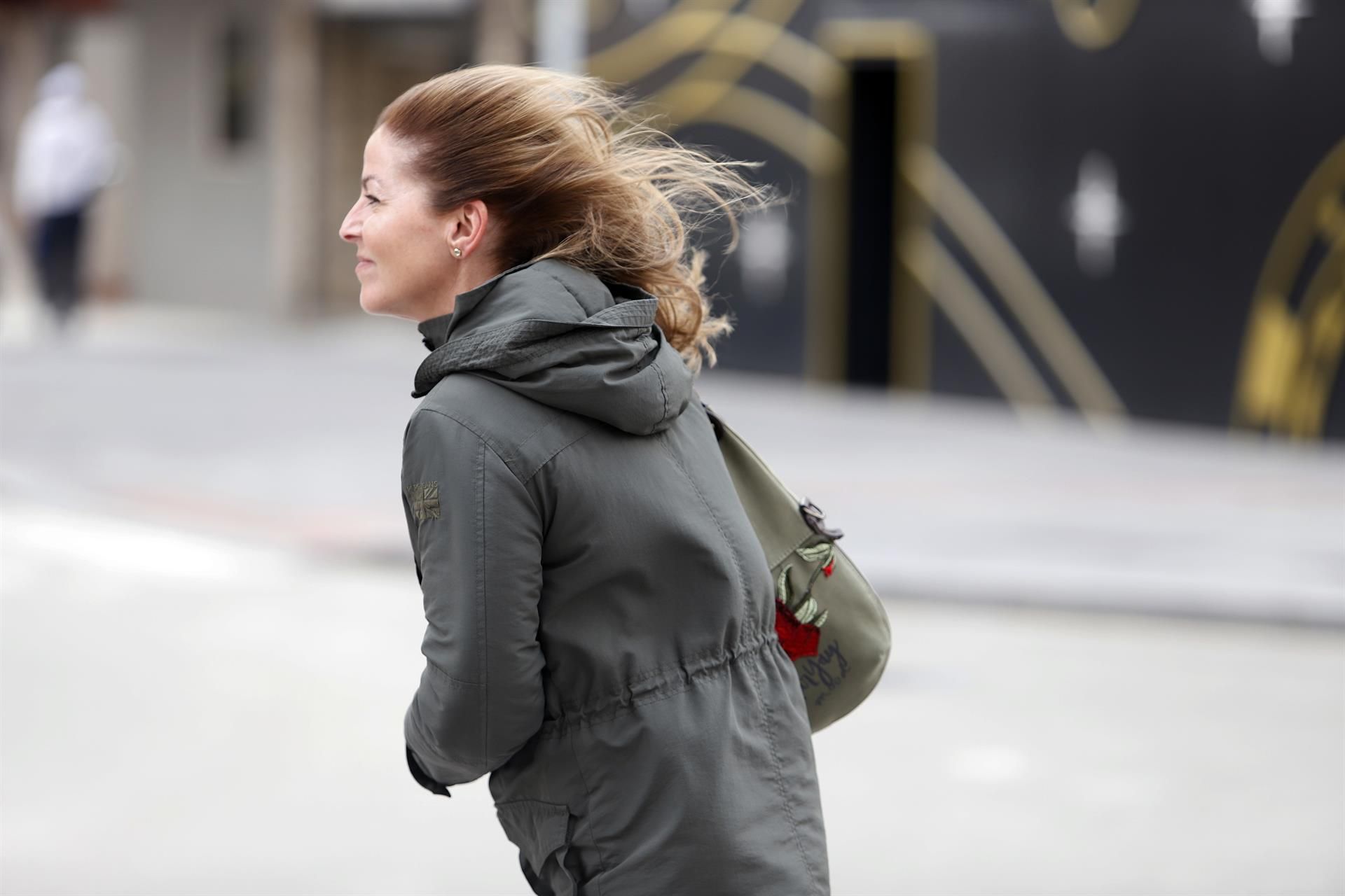 Una mujer intenta andar por la calle en un temporal marcado por las fuertes rachas de viento. | EP