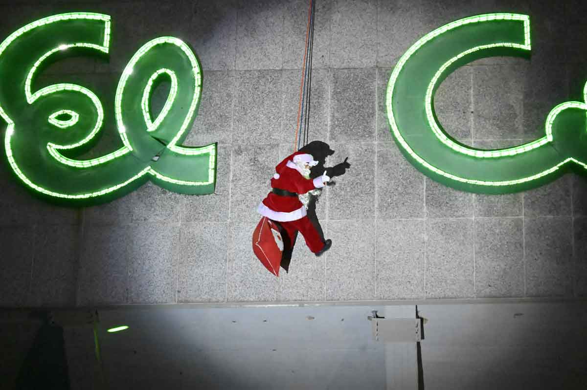 Papá Noel descendió este domingo por la facha de El Corte Inglés de León. SAÚL ARÉN