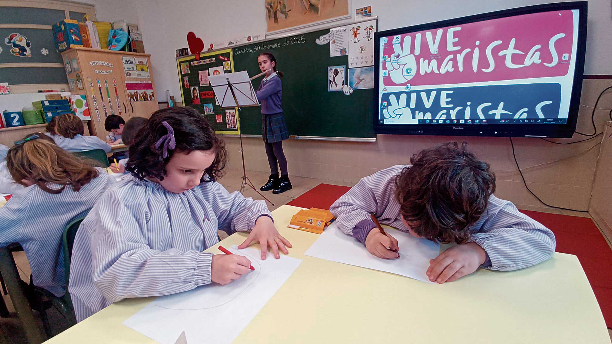 Nadia interpreta una pieza musical con su flauta travesera; las alumnas escuchan y llevan a sus dibujos las sensaciones que les transmite la música.
