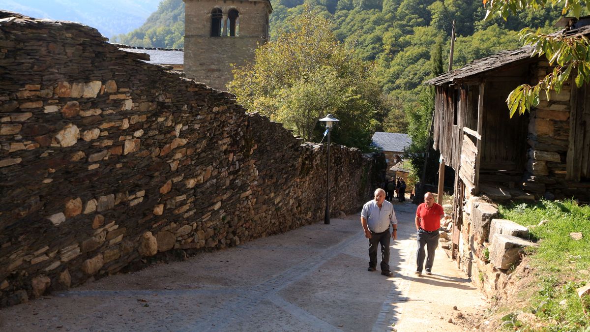 Dos personas pasean por las calles de Montes de Valdueza que fueron urbanizadas en 2015. | CÉSAR SÁNCHEZ (ICAL)