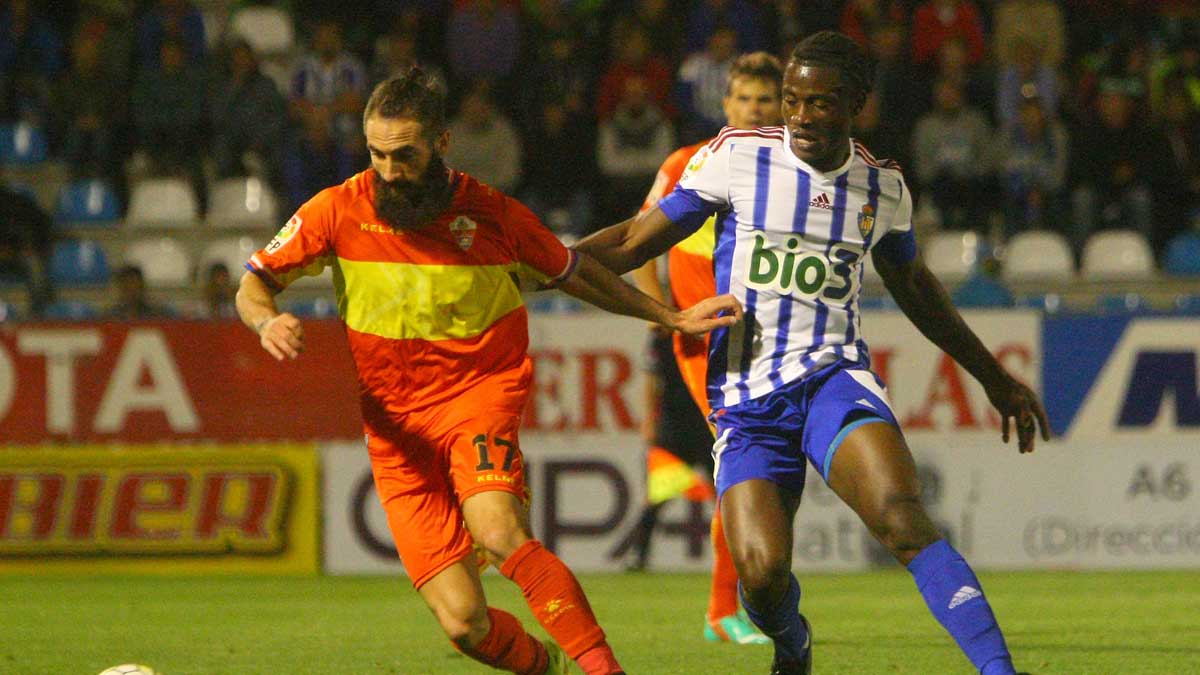 Jebor pelea un balón con un jugador del Elche en el partido disputado en El Toralín. | CÉSAR SÁNCHEZ
