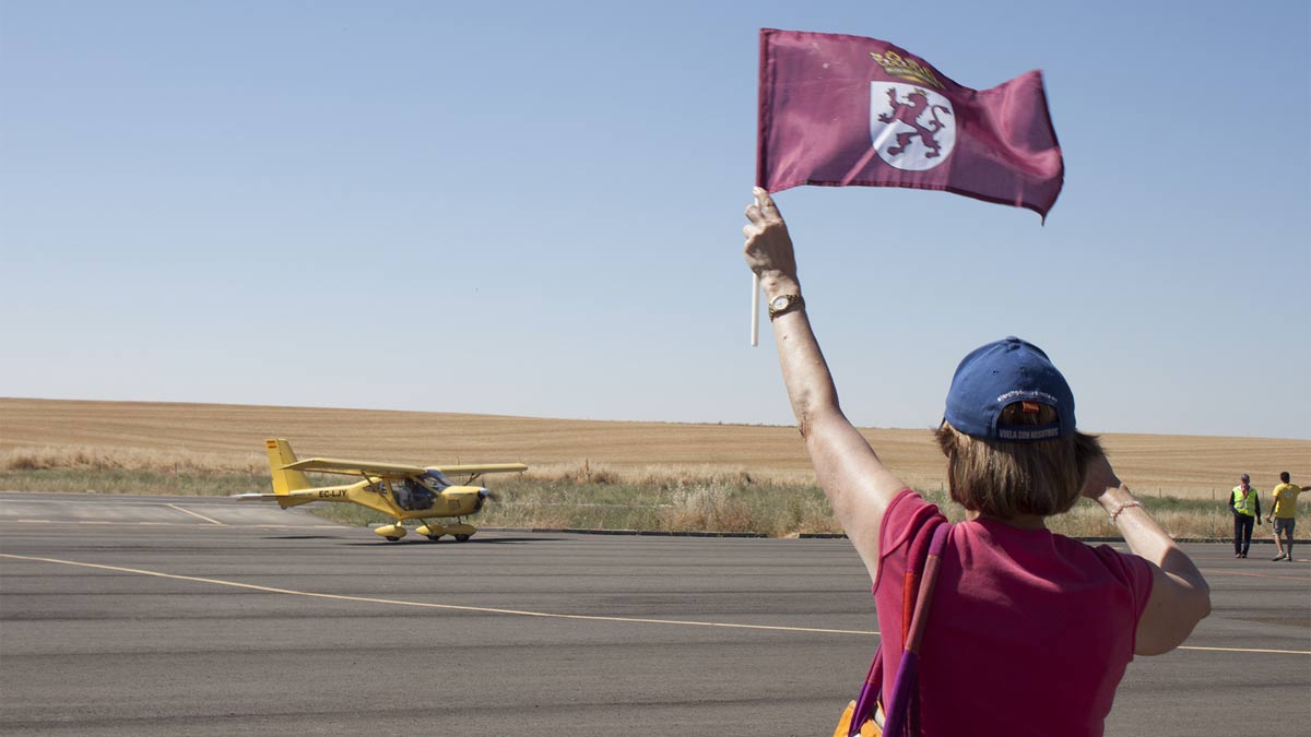Maite recibe a su hermano Manolo en su llegada al aeródromo de Los Oteros con una bandera de León. | T.G.
