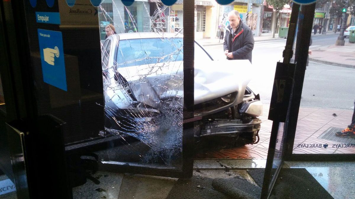 El coche empotrado en la oficina bancaria de la avenida La Puebla en Ponferrada. | L. N. C.