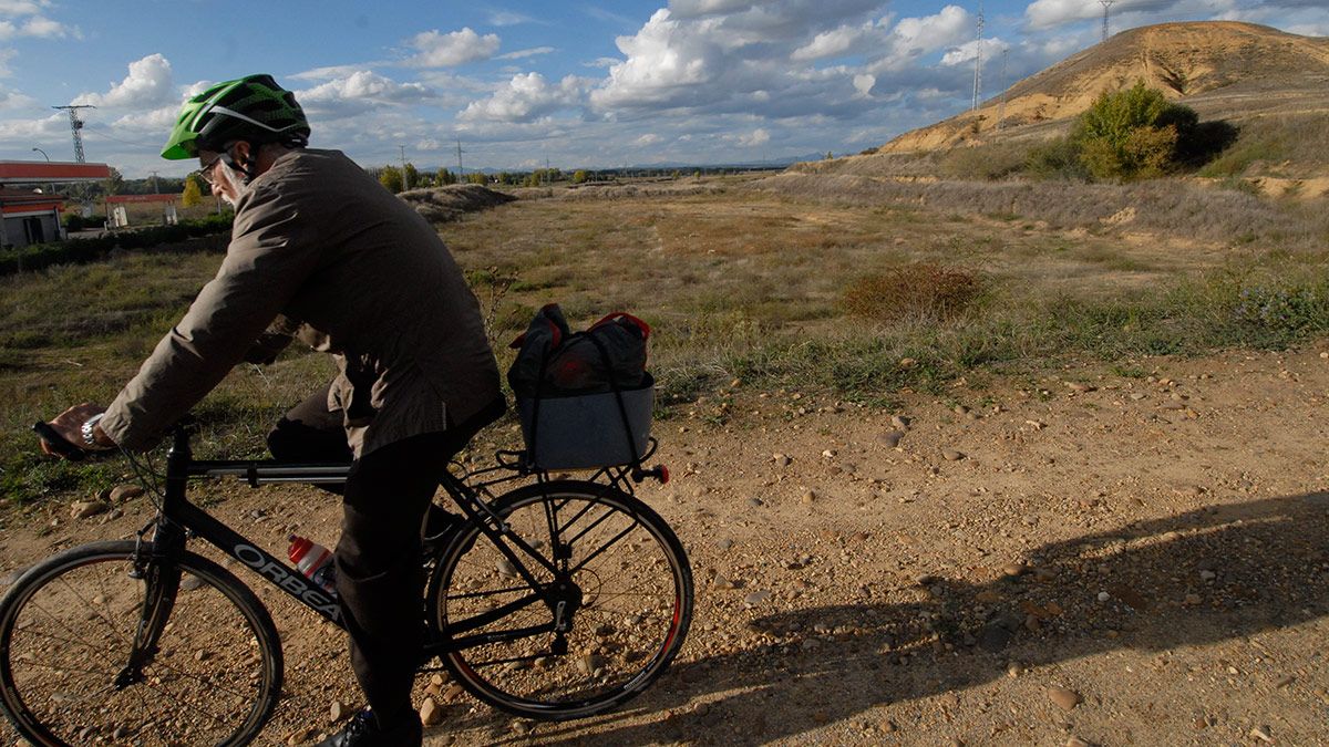 Un ciclista pasa junto a los restos arqueológicos del yacimiento de Lancia, que ha supuesto un importante escollo para la autovía hasta Valladolid. | MAURICIO PEÑA