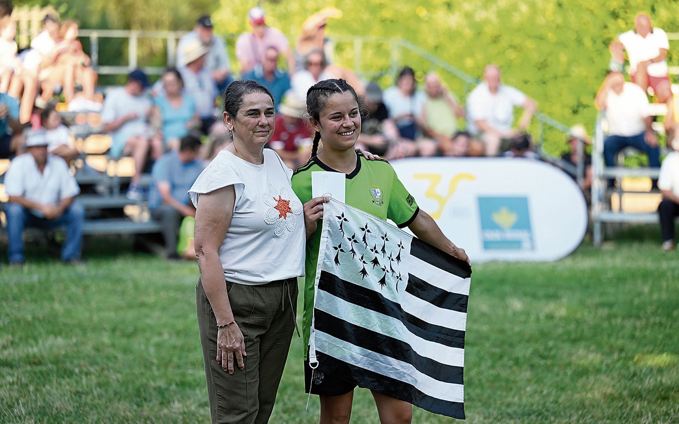 La luchadora bretona Lea Quilian mostrando la nueva bandera que se incorpora a  las de los campeones de lucha leonesa. SAÚL ARÉN