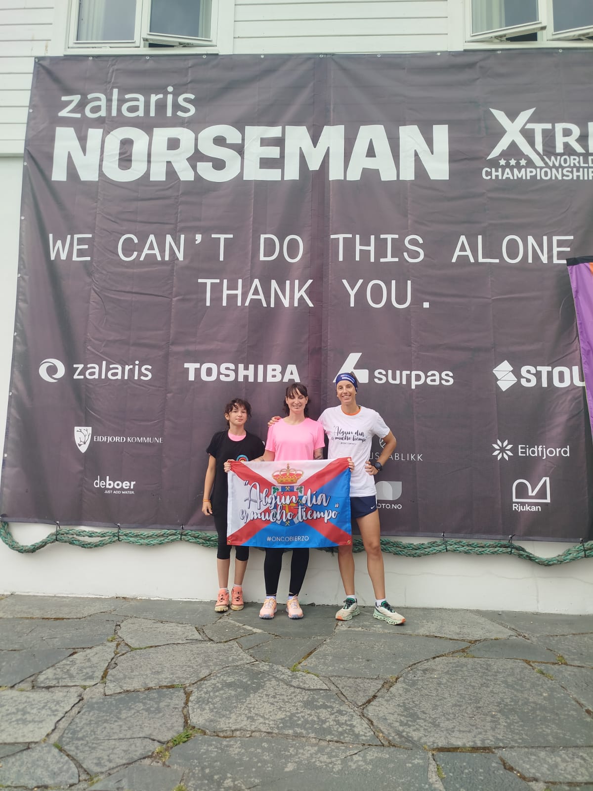 Carolina con Murieta y la bandera de Oncobierzo en la meta de la exigente triatlón. 