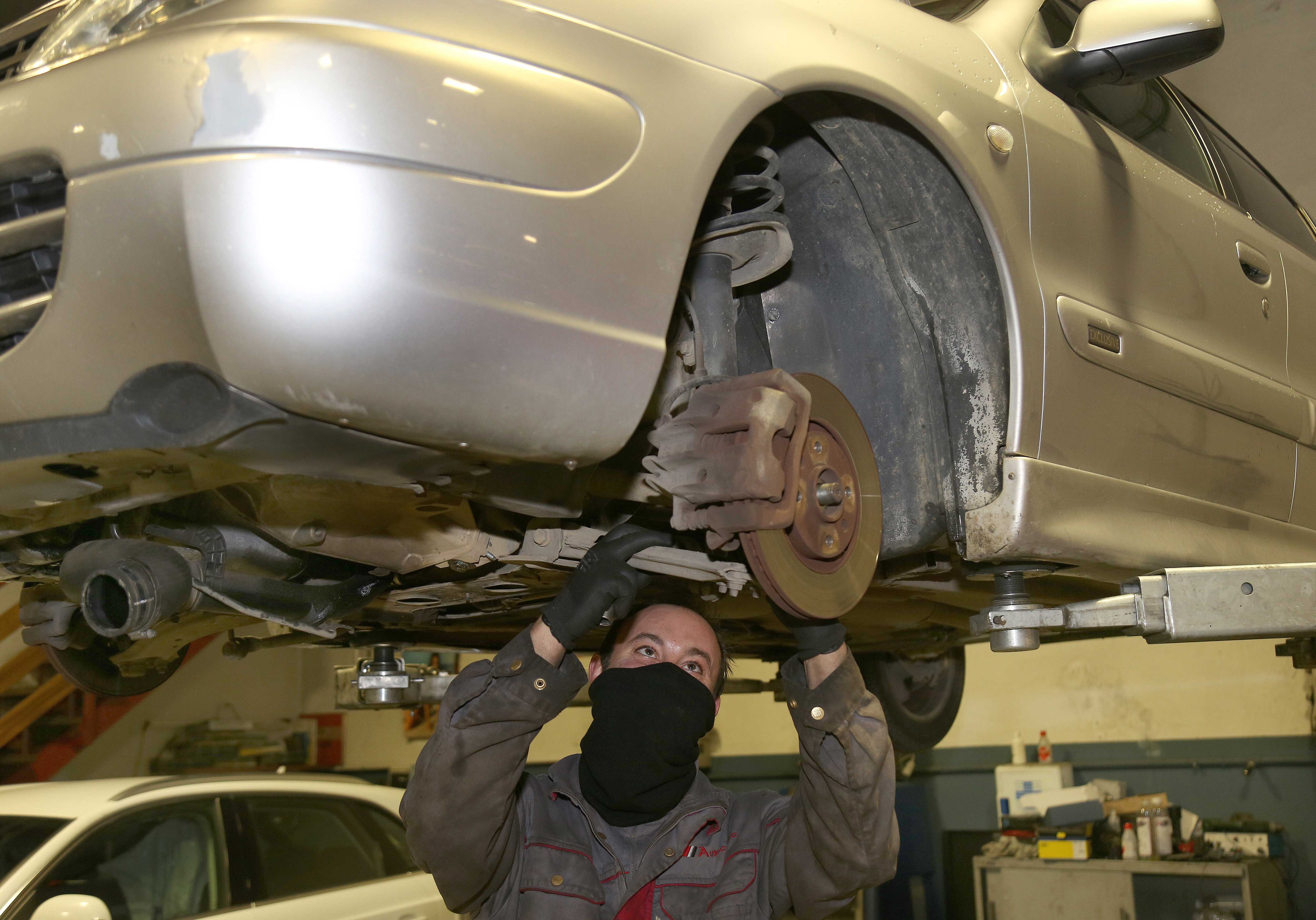 Imagen de archivo de un mecánico trabajando en un automóvil. | ICAL