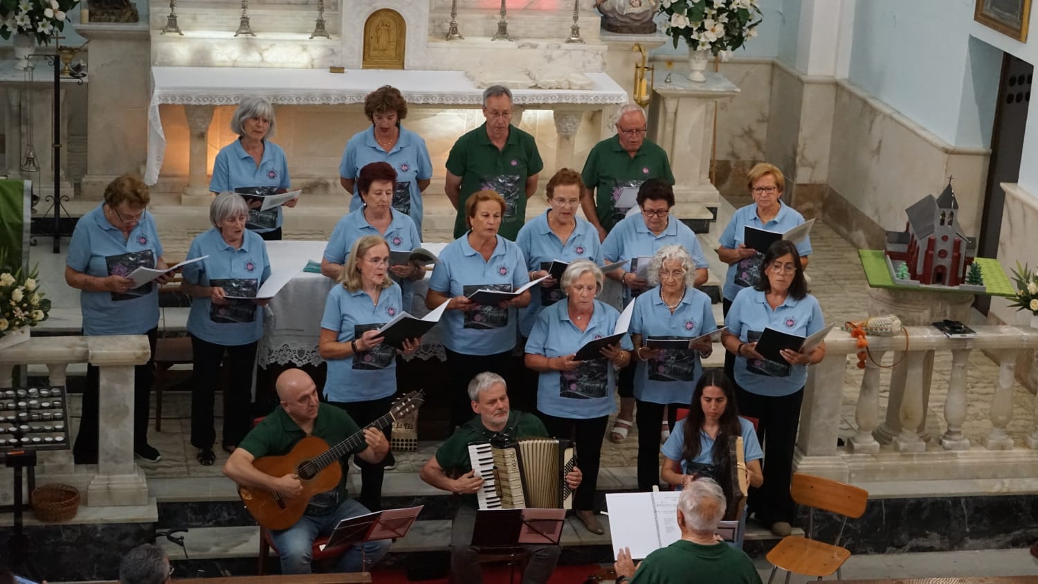 La iglesia de Cármenes se llenó para la presentación del libro ‘Flor del viento’ con un concierto del coro local. | TOLO GIL