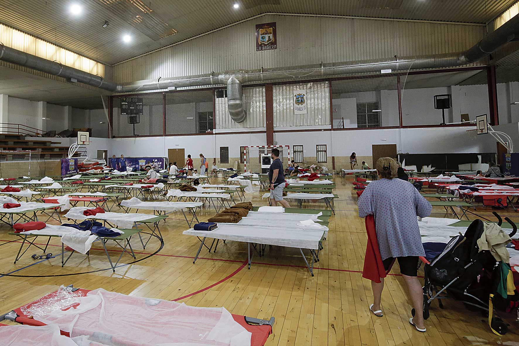 Las personas evacuadas tienen a su disposición cama y comida en el pabellón de La Bañeza. | FERNANDO OTERO