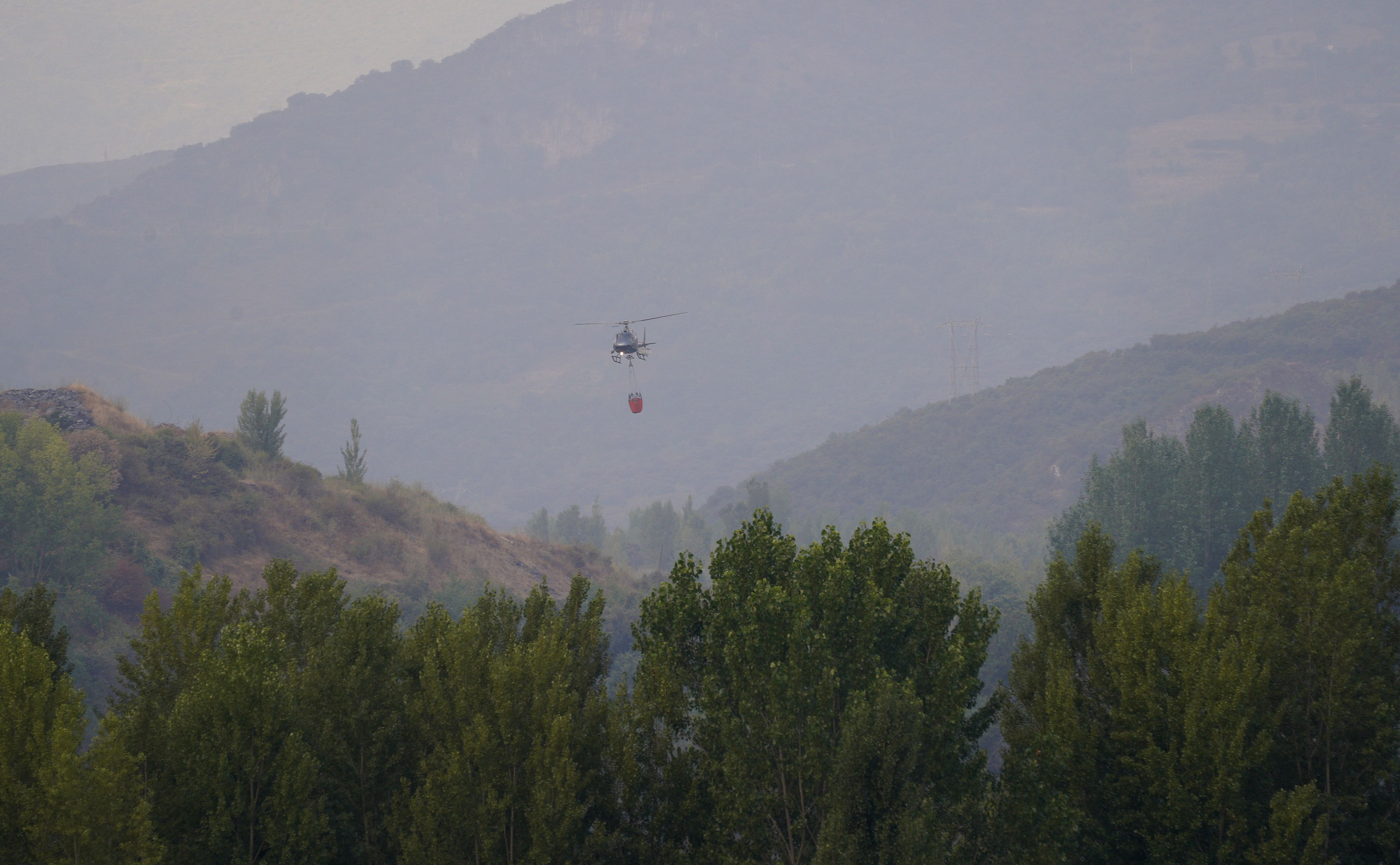 Un helicóptero sofocando un incendio en el Bierzo. | CÉSAR HORNIJA (ICAL)