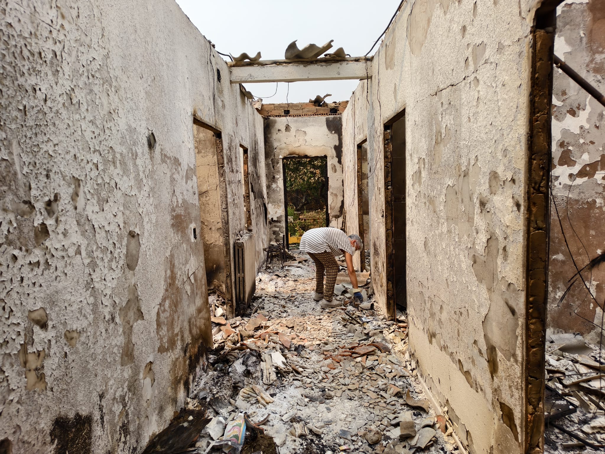 María Josefina intentado recuperar algunos de sus recuerdos en su casa que quedó totalmente calcinada. | ALEJANDRO RODRÍGUEZ