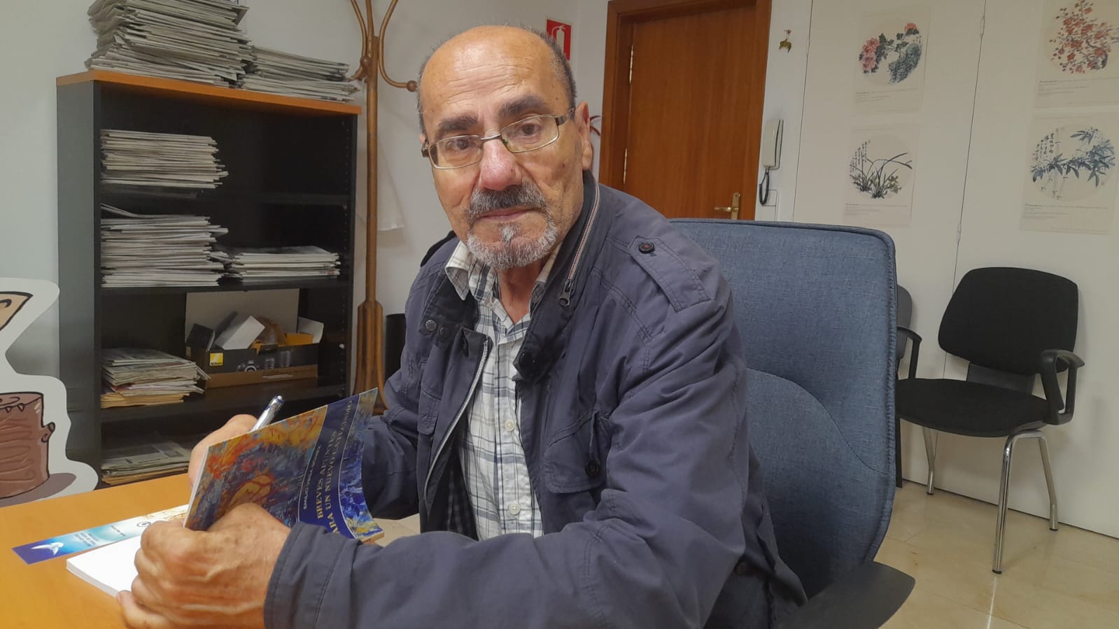 El autor con uno de sus libros en la sede de La Nueva Crónica en Ponferrada.| M.I.