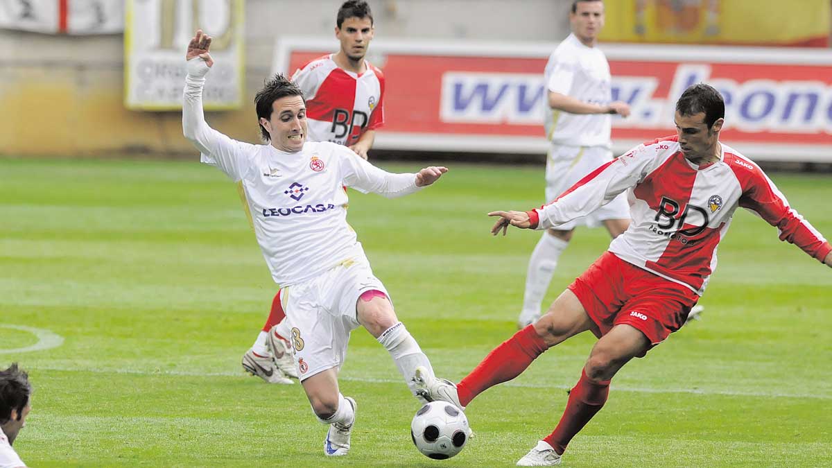 Rubén García pelea por un balón ante el Sabadell con la mirada al fondo de Santi Santos. | MAURICIO PEÑA