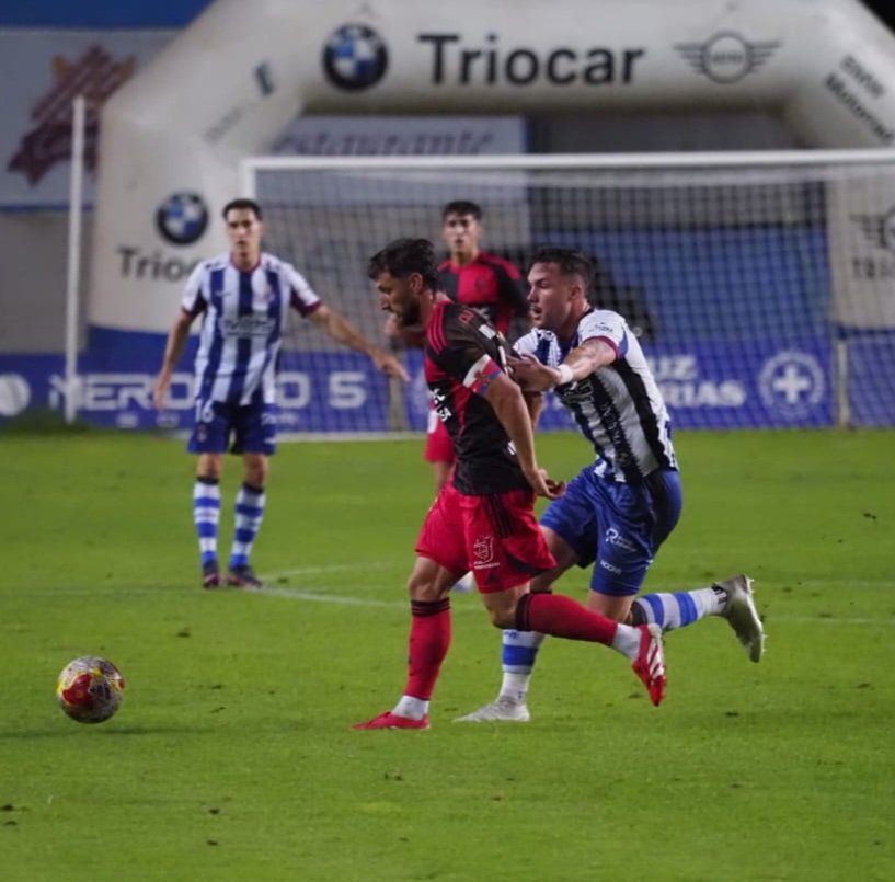 Borja Valle, autor del segundo gol, pugna por un balón dividido con el defensor del Avilés.  REAL AVILÉS