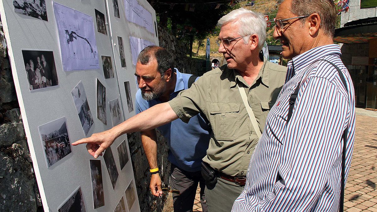 Tres de los homenajeados miran fotos de la época del descubrimiento de las Cuevas de Valporquero. | ICAL