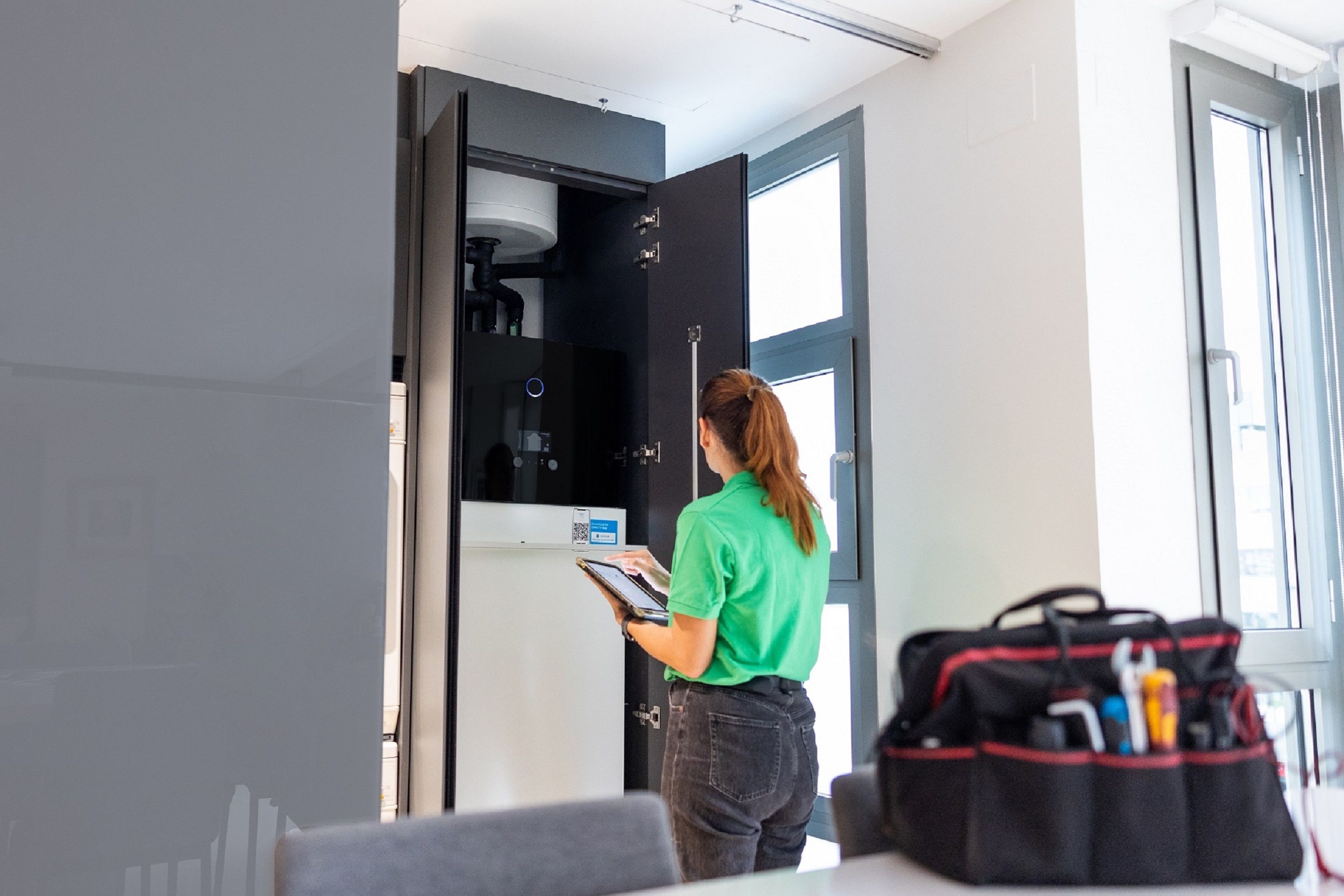 Técnico de Iberdrola ante la unidad interior de aerotermia en una vivienda.