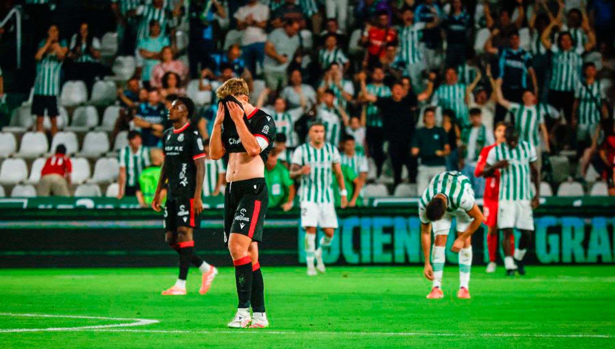 Rodri y Selu se lamentan tras pitar el final que celebran jugadores y afición del Córdoba. | LALIGA