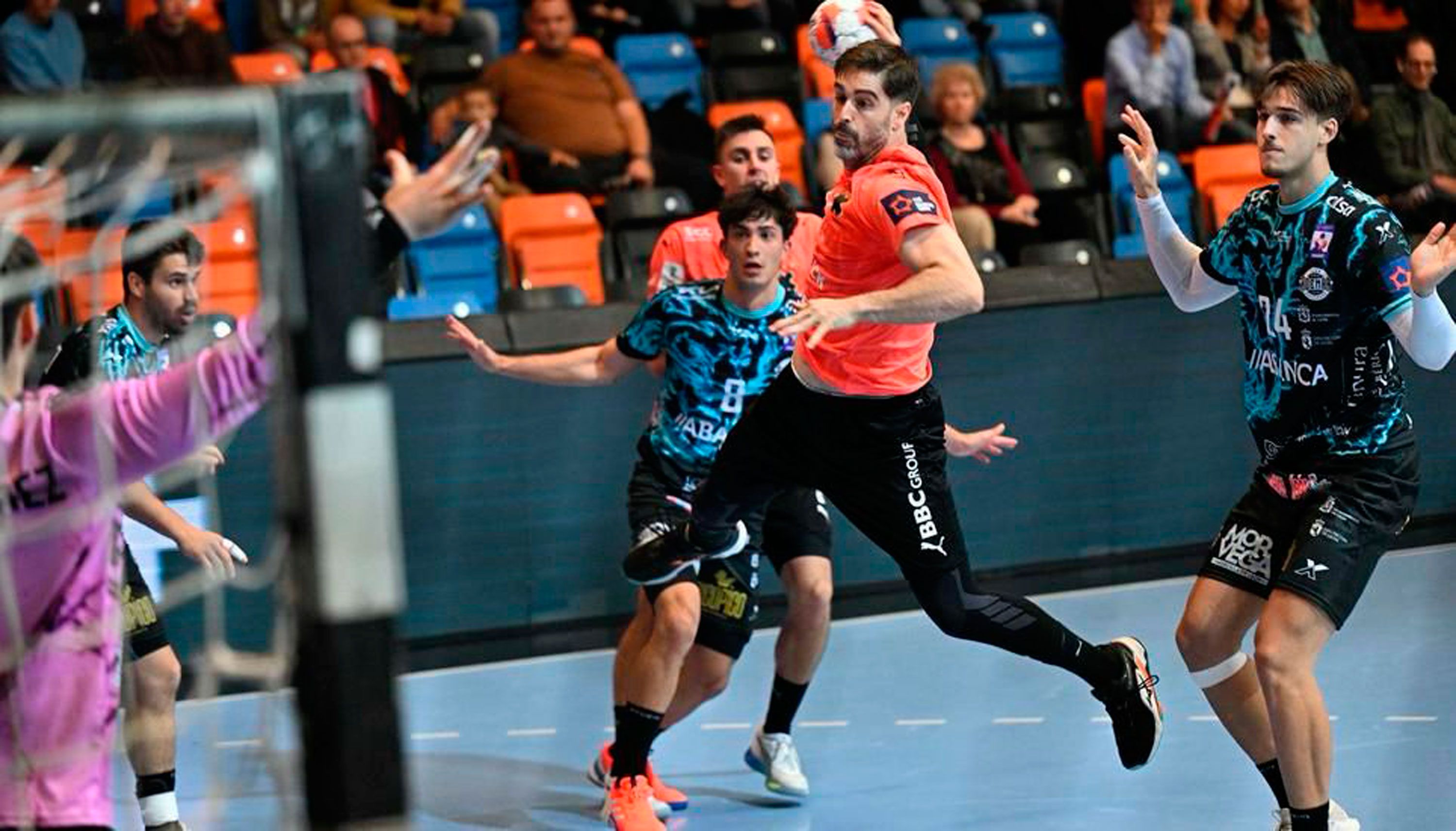 El central leonés del Kadetten, Juan Castro, lanza entre defensores del Ademar. | MICHAEL KESSLER (SCHAFFHAUSER NACHRICHTEN)