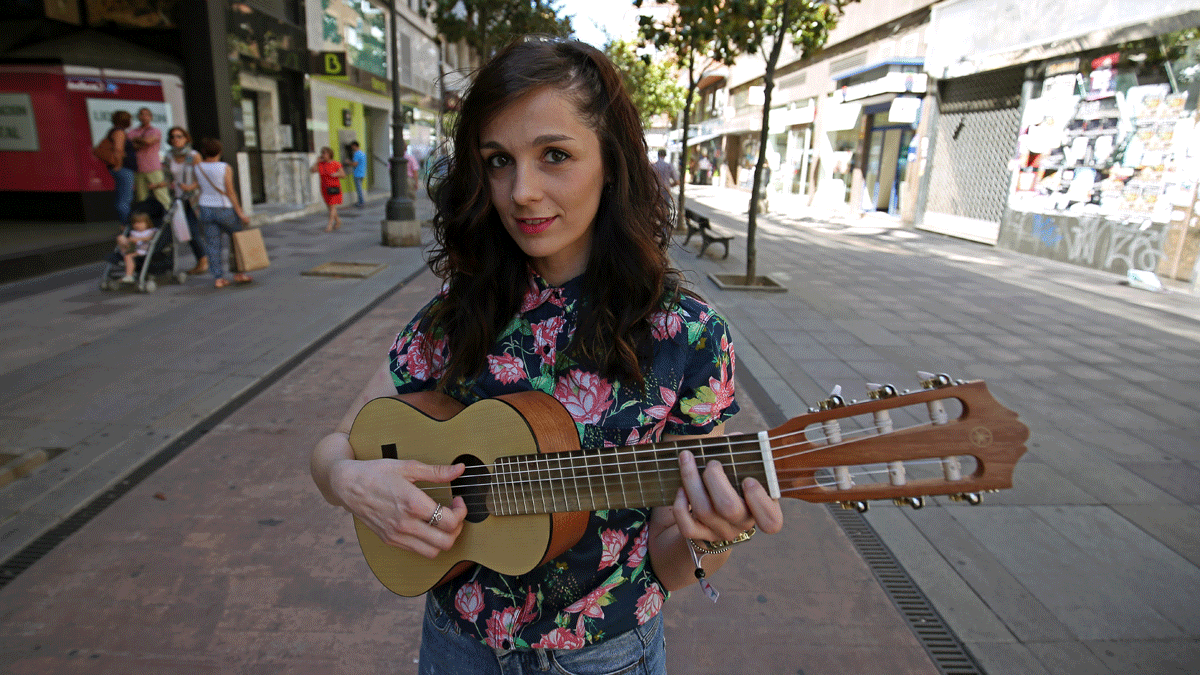 La cantautora ponferradina Cia Campillo, que va a sacar su primer disco a través de una campaña de crowdfunding posa con su instrumento en la avenida de España. | César Sánchez (Ical)