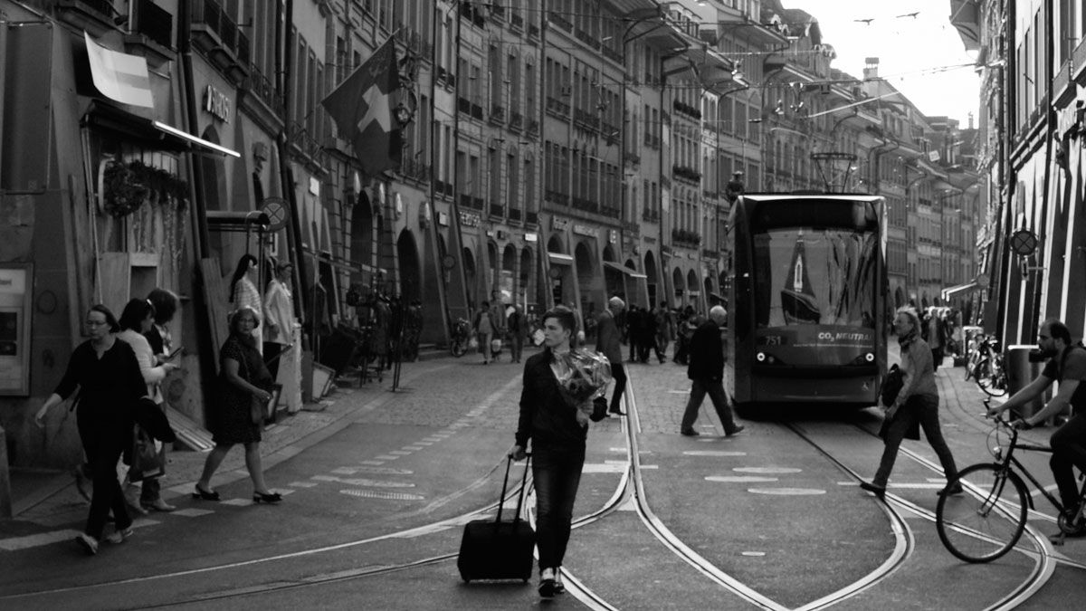 Un chico con un ramo de flores y una maleta, en Berna. | PABLO J. CASAL