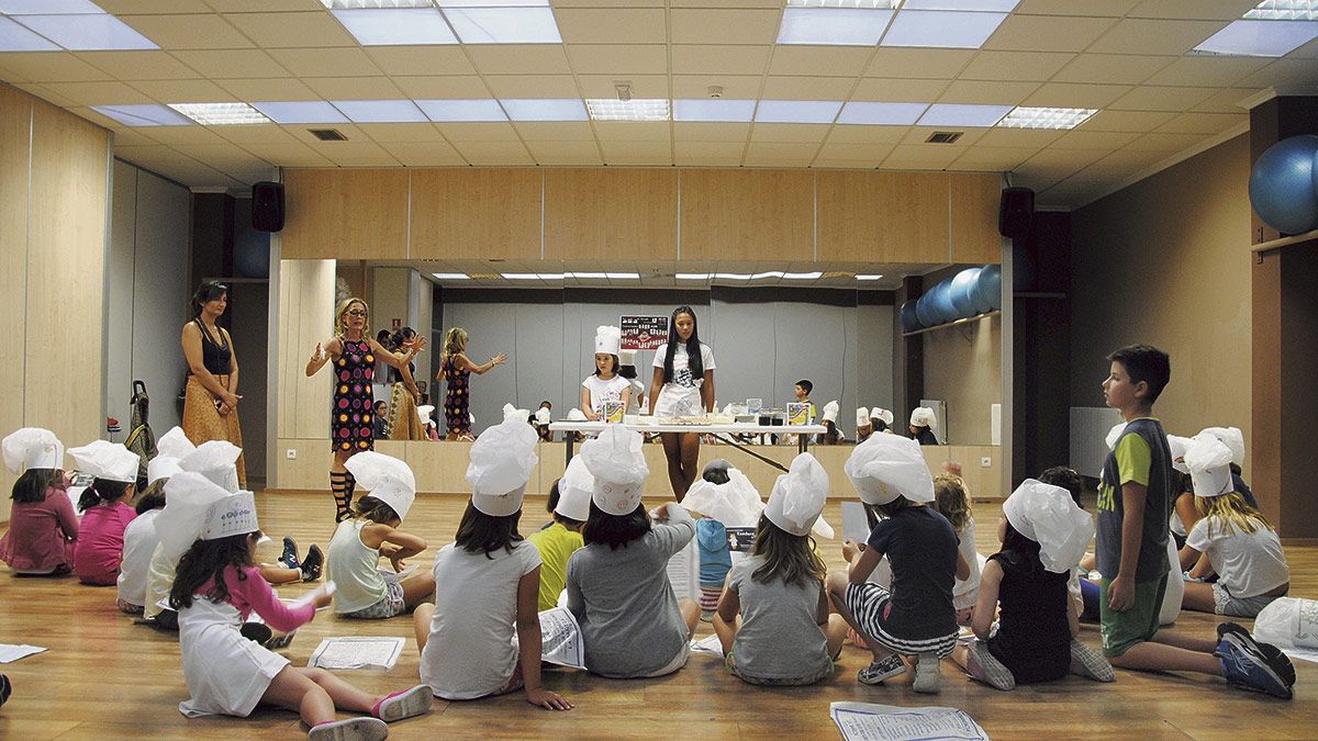 Para preparar la receta de la tarta, los niños atendieron las explicaciones de María, que estuvo en La Bañeza. | ABAJO Para preparar la receta de la tarta, los niños atendieron las explicaciones de María, que estuvo en La Bañeza. | ABAJO