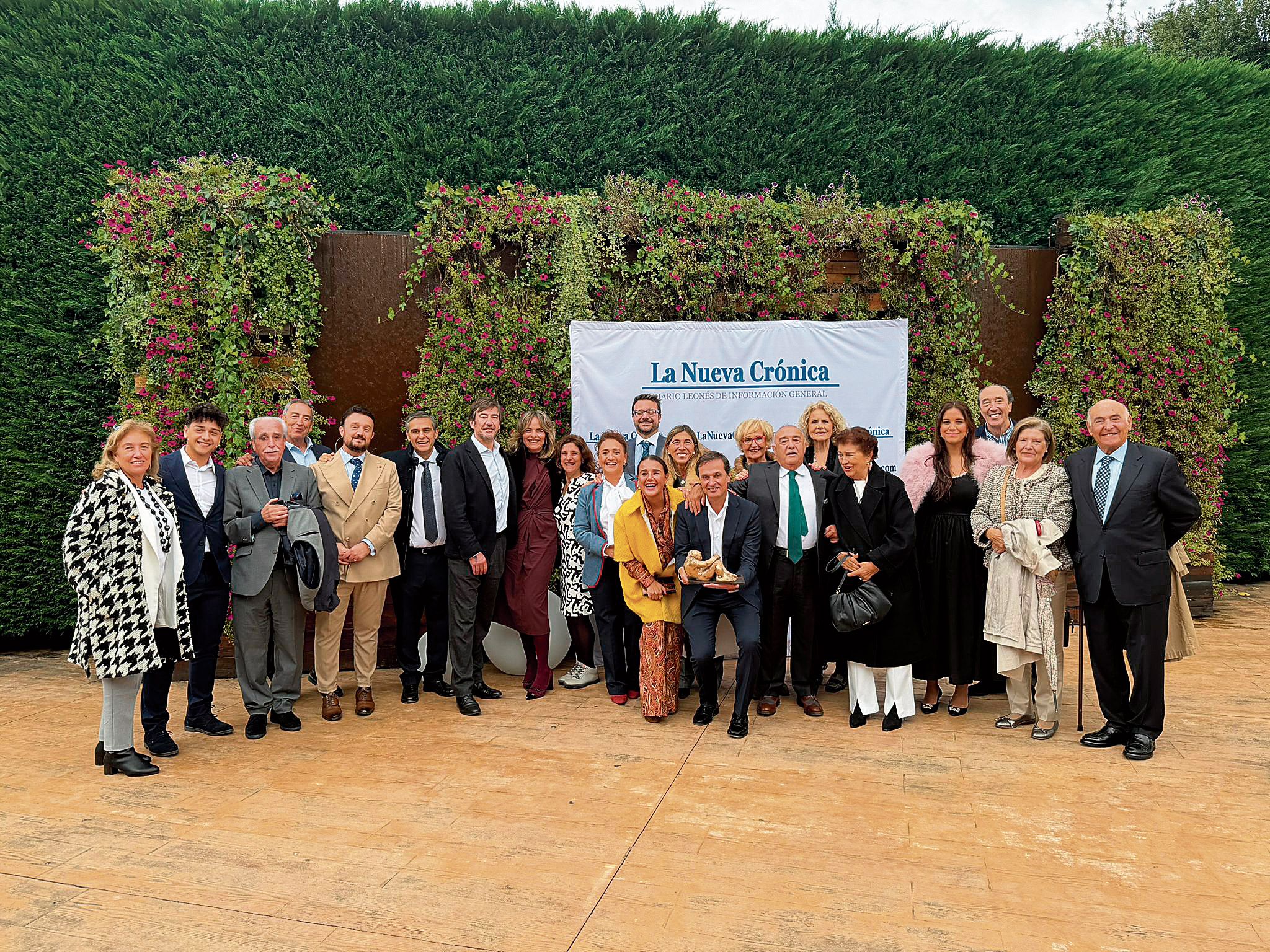 Las familias Lesmes y Lamelas y numerosos amigos posan con el presidente del Consejo Regulador DO Bierzo y la Negrilla de Oro durante un momento de la fiesta.