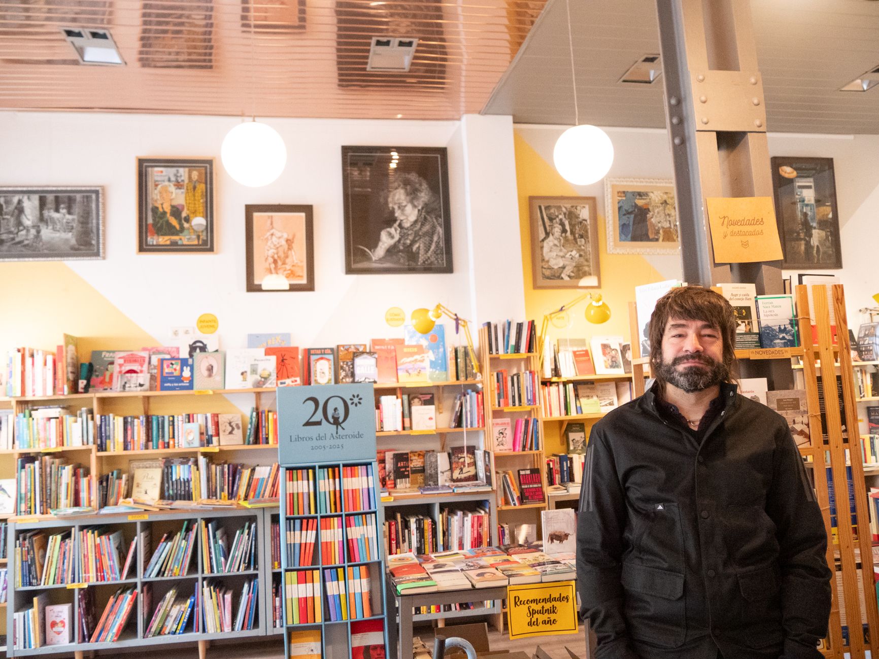 El artista Álvaro Pedraz ante los libros y sus piezas, expuestas hasta enero en la librería cafetería La monta Sputnik. | VICENTE GARCÍA
