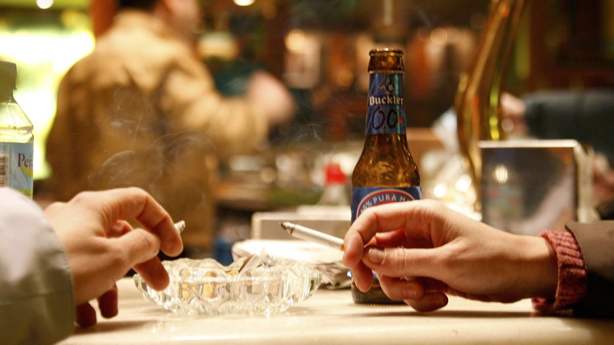 Una imagen que ya no se puede ver en los bares españoles:dos personas fumando dentro de un local. | ICAL
