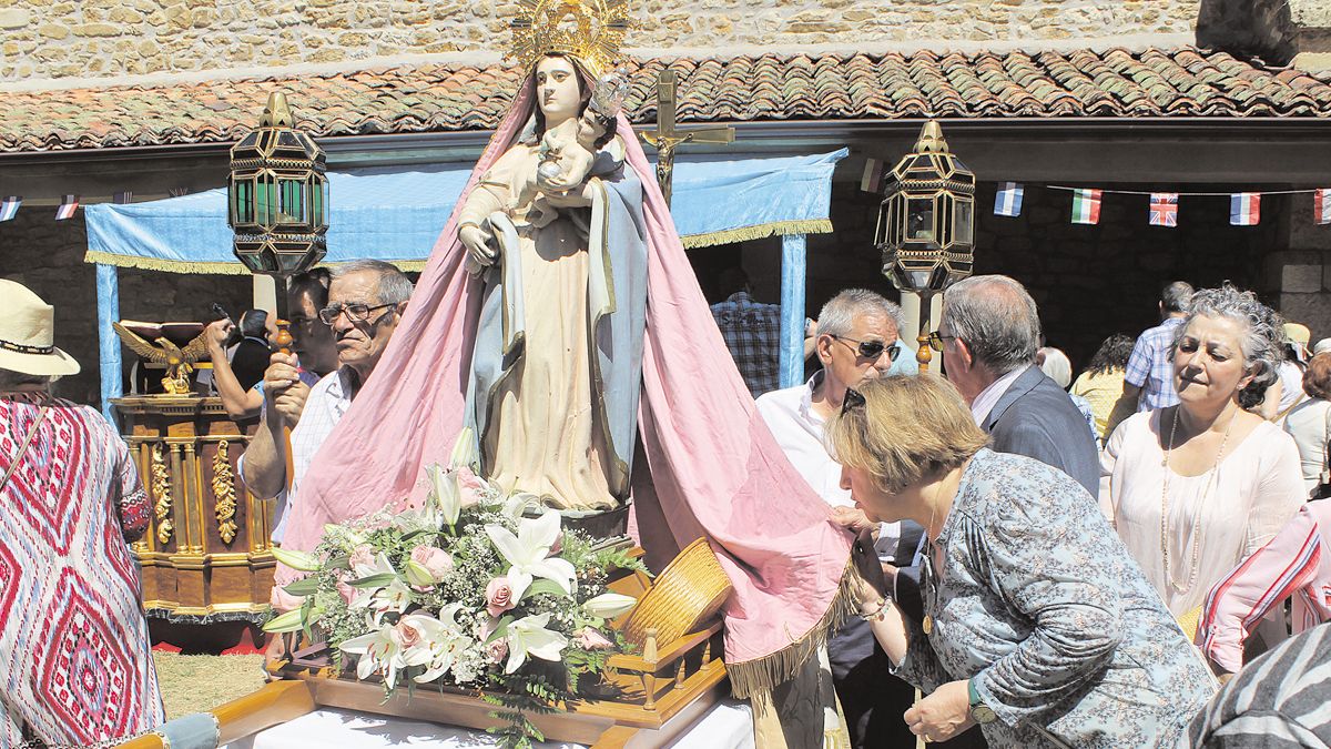 Una mujer besa el manto de la Virgen de los Remedios. | ALFREDO HURTADO