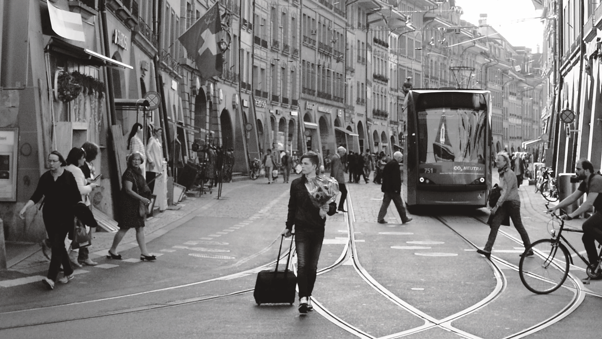 Un chico con una maleta y un ramo de flores, en Berna.| PABLO J. CASAL