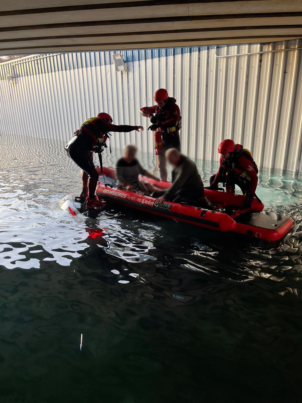 Los bomberos durante el rescate de las dos personas que iban en el vehículo. | BOMBEROS DE LEÓN