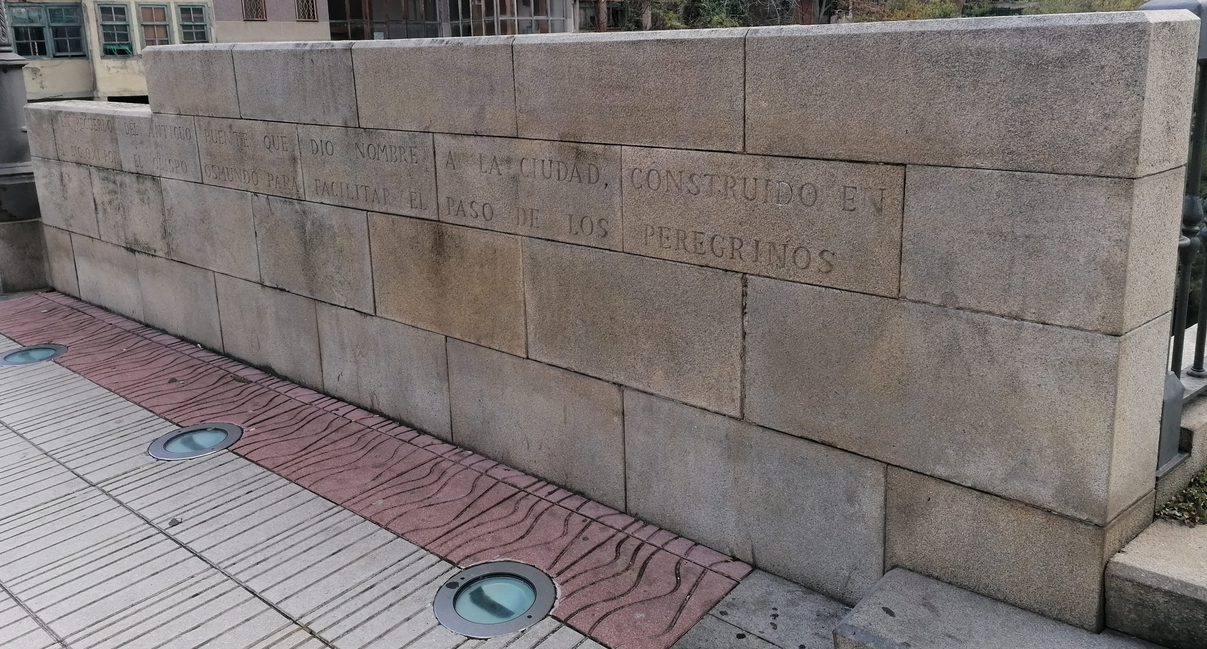Muro donde se puede leer 'En recuerdo del antiguo puente que dio nombre a la ciudad...'