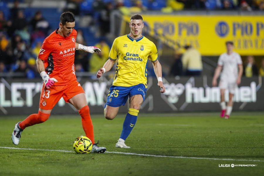 El portero de la Cultural, Badia, da un pase ante la presión de un atacante de Las Palmas. | LALIGA