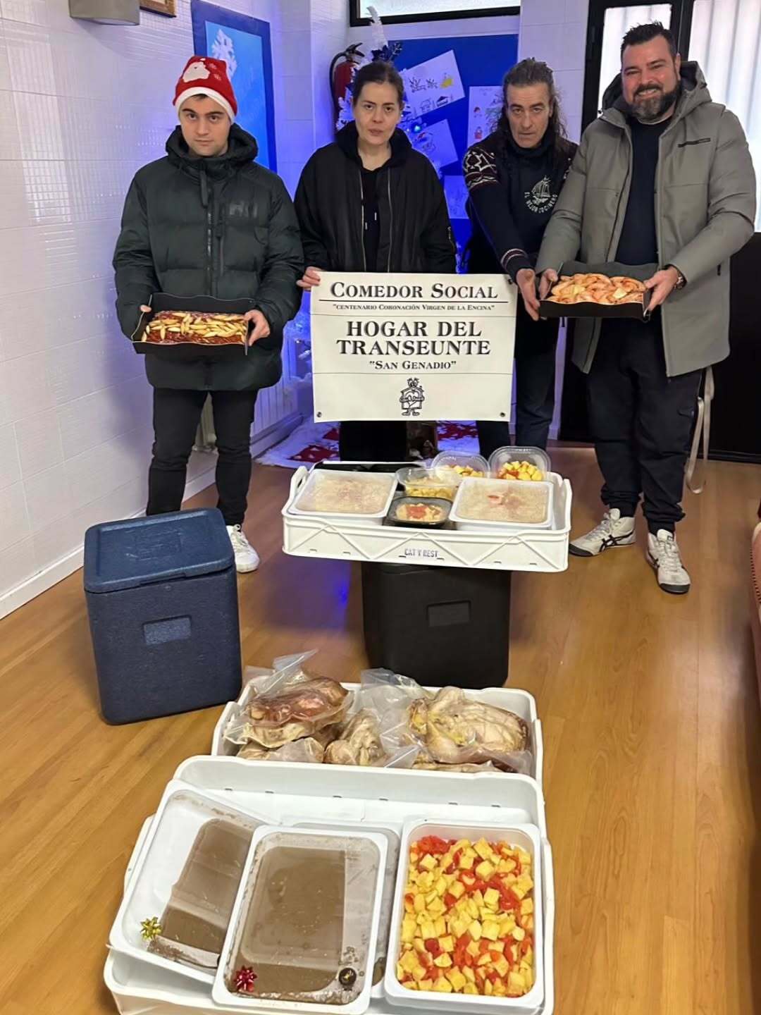 Un instante de la entrega de los menús por parte de Representantes en el comedor social del Hogar del Transeúnte de Ponferrada. | CAT&REST