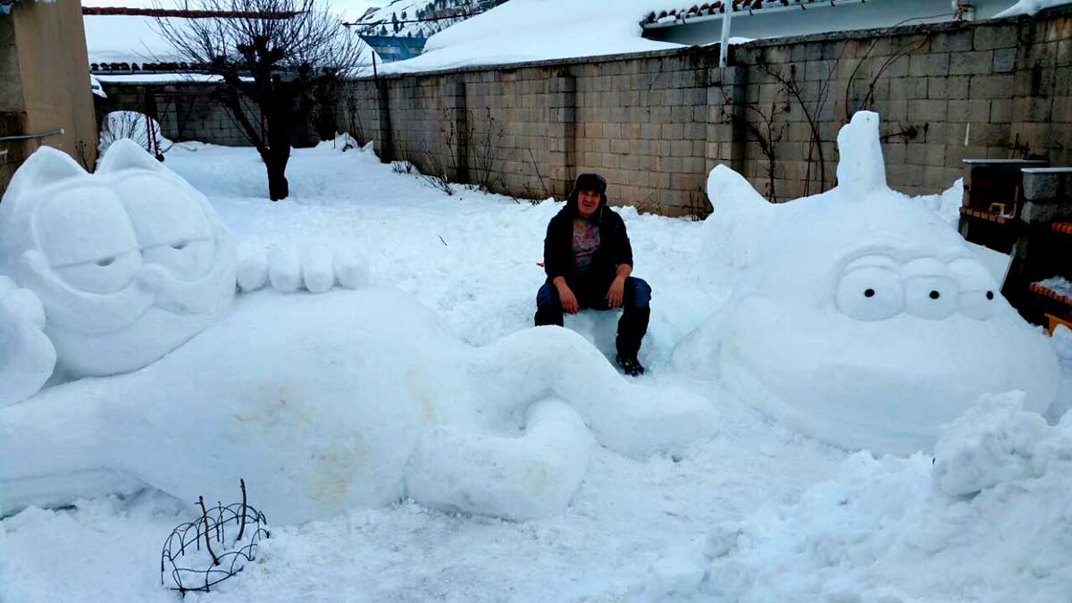 Sergio Canga con dos de sus enormes esculturas que han dado el toque divertido a la nevada en Ciñera.