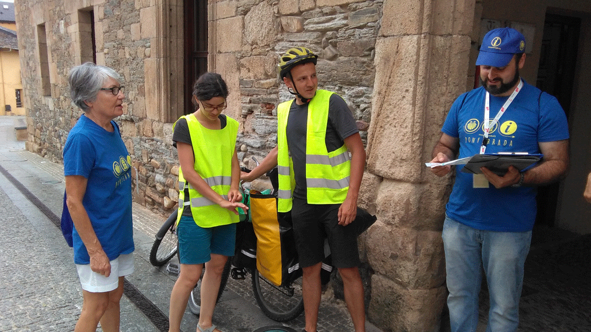 Varios de los alumnos participantes en el programa de voluntariado, junto a peregrinos en el casco antiguo de Ponferrada. | D.M.