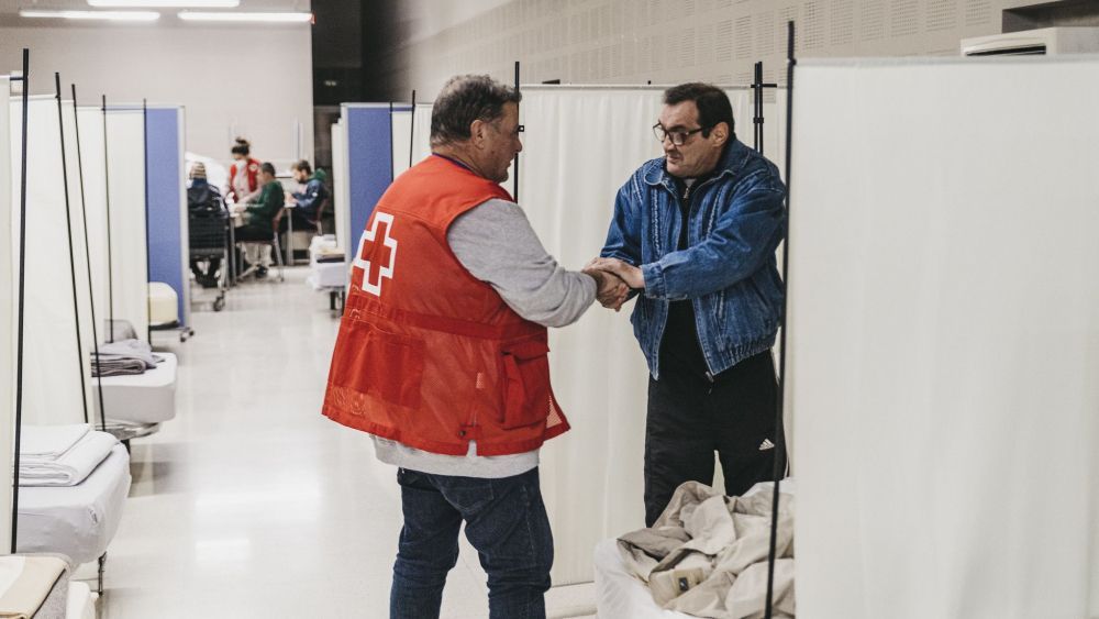 Un voluntario de Cruz Roja atiende a una persona. | CRUZ ROJA