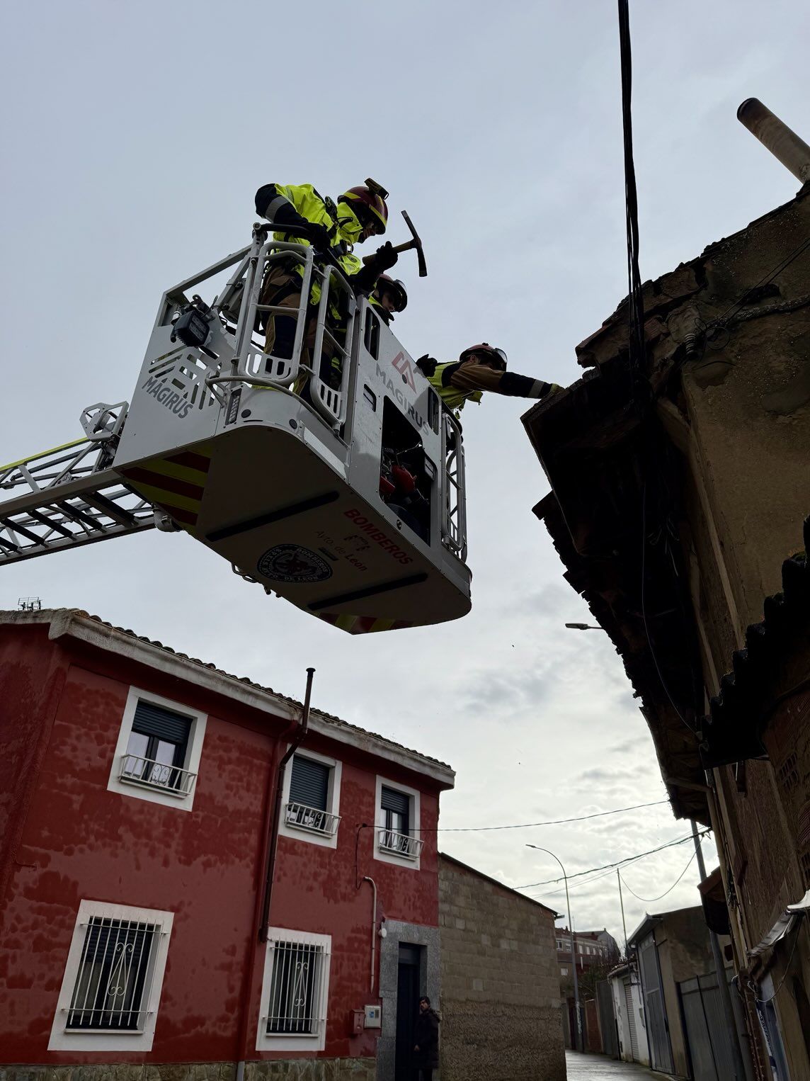 Los bomberos de León retirando las tejas de una vivienda en mal estado de Puente Castro. | BOMBEROS DE LEÓN