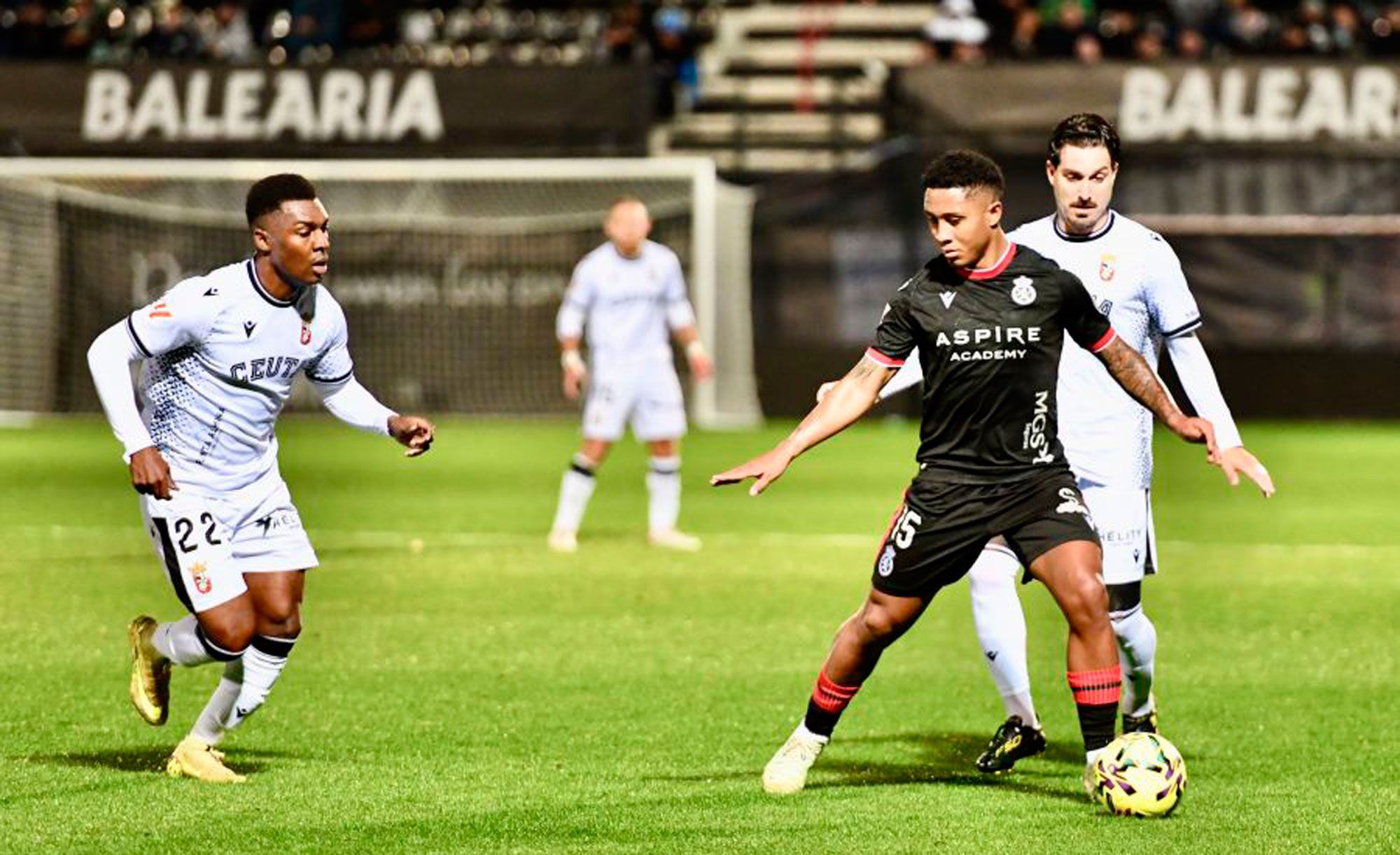 Lucas Ribeiro encara a dos defensores delCeuta durante el encuentro.  LALIGA