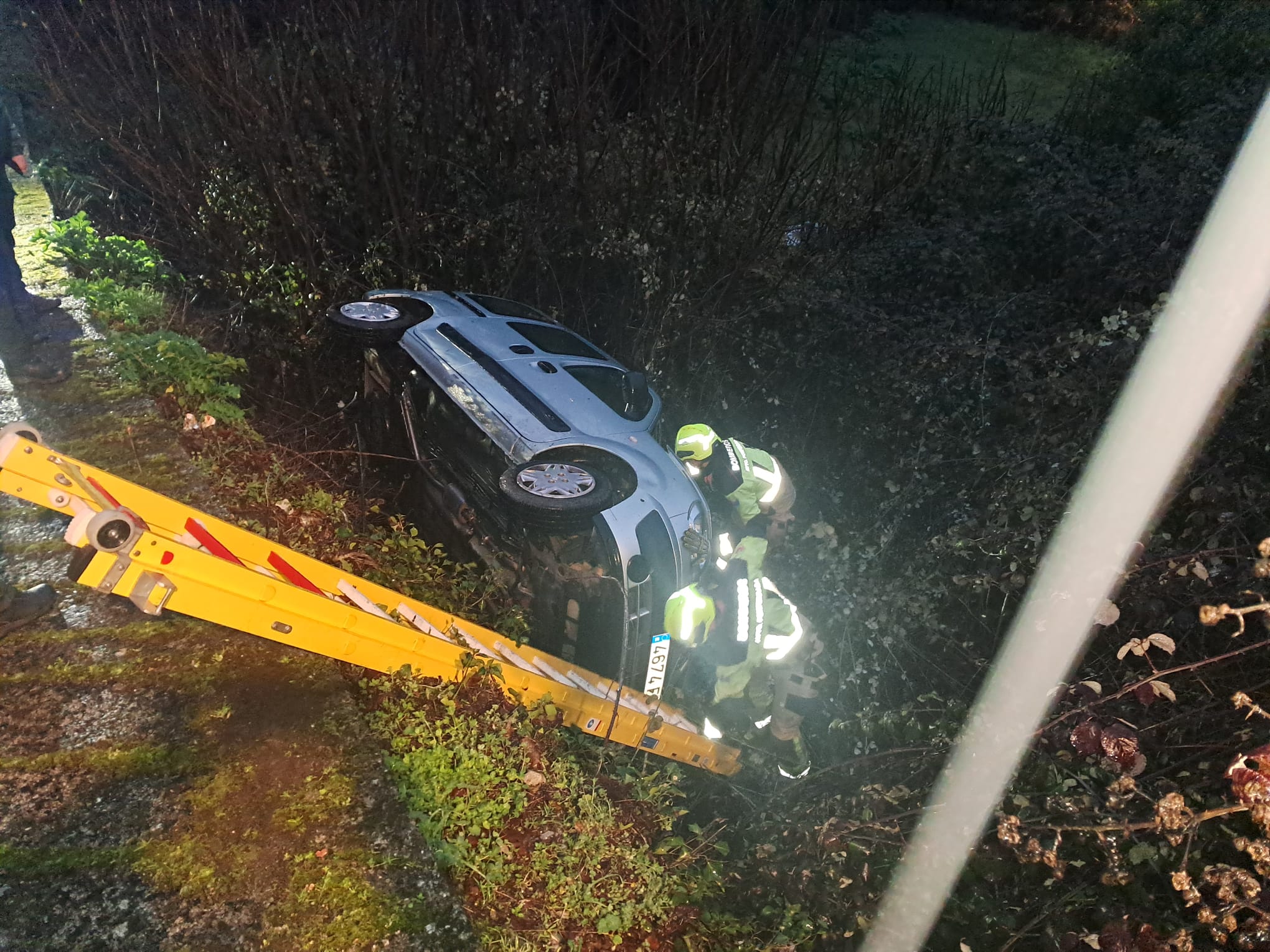 El coche accidentado tras caer por el terraplén. | BOMBEROS PONFERRADA