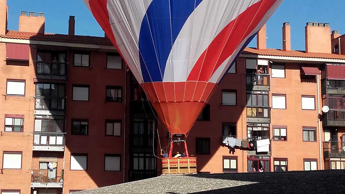 Uno de los globos aerostáticos del XIII Trofeo Diego Criado del Rey aterriza en el patio interior de unas viviendas del barrio de la Victoria. | ICAL