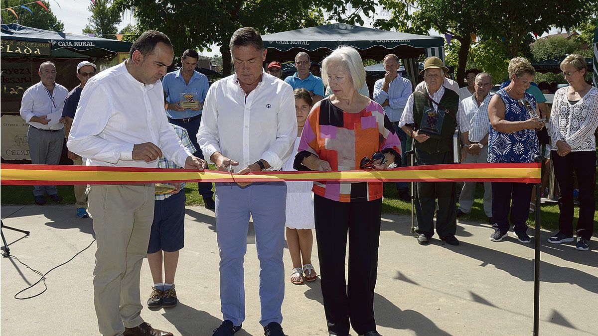 El alcalde de Cuadros, Marcos Martínez, cortando la cinta de inauguración de la feria de artesanía.| MAURICIO PEÑA