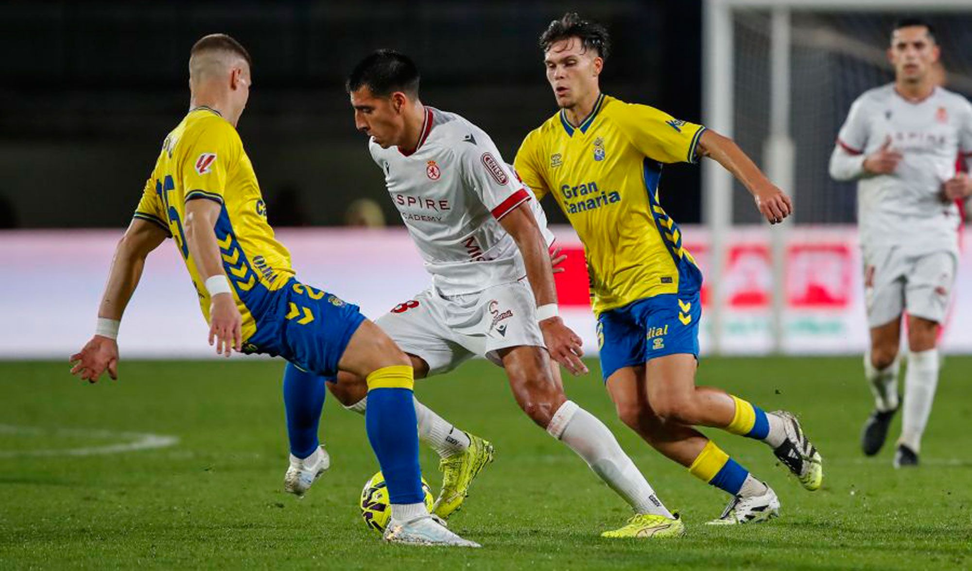 Ojeda intenta zafarse de dos defensores en el Las Palmas - Cultural de la primera vuelta.  LALIGA