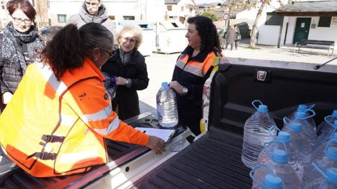 Reparto de las garrafas entre los vecinos de Toral de Merayo tras quedar sin captación. | ICAL