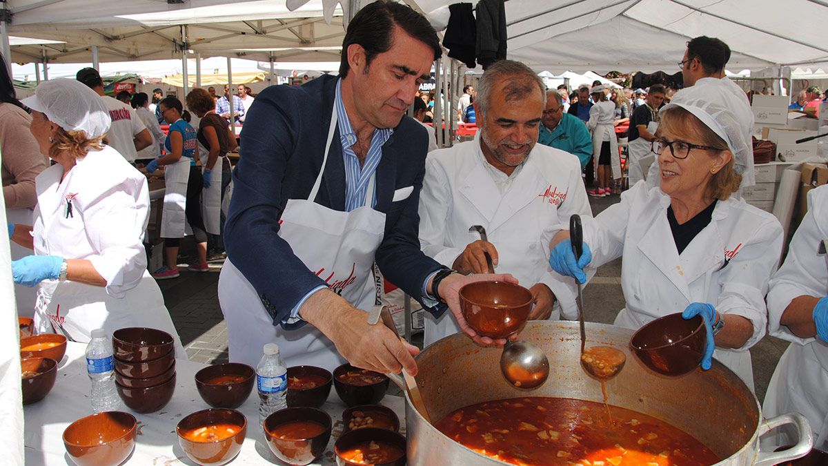 El consejero de Fomento junto al alcalde de La Bañeza sirviendo alguna de las raciones servidas en esta Alubiada. | ABAJO