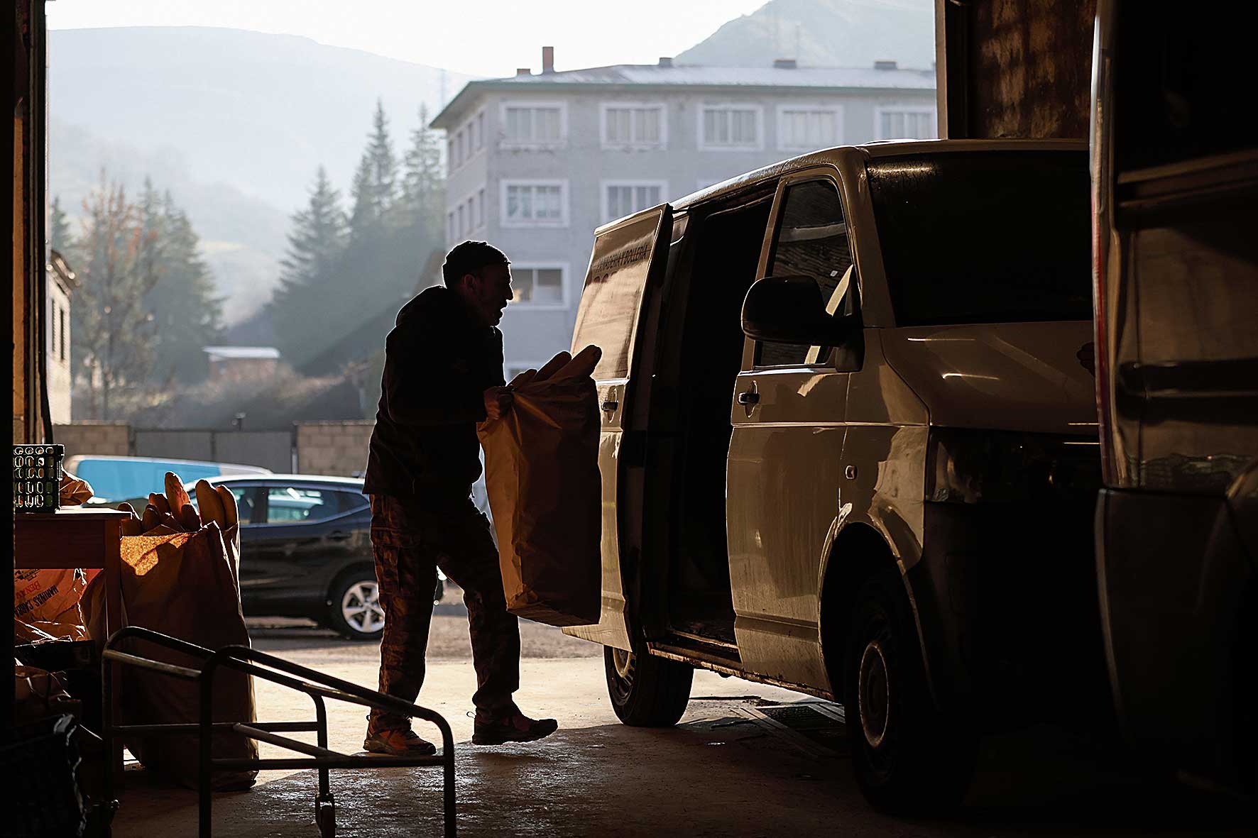 Constantino(Tino) mete los últimos sacos de pan en la furgoneta para marchar camino de Asturias, llega hasta comercios de Oviedo. | FERNANDO OTERO
