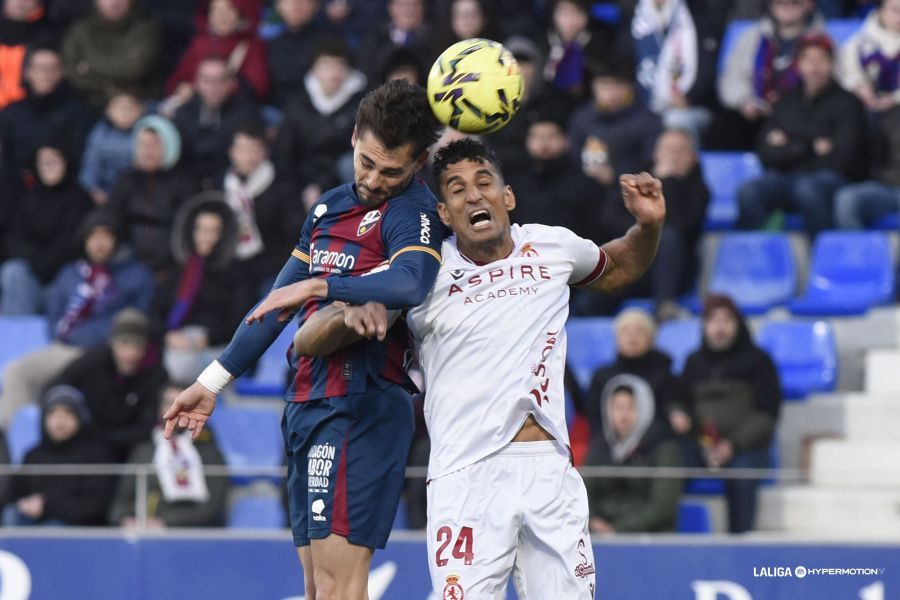 El lateral derecho de la Cultural, Víctor, pelea un balón aéreo con el defensor del Huesca. | LALIGA