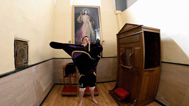 Mariano ‘aparca’ las deportivas —«¿porqué vas descalzo?», le pregunta su hijo— para vestirse de Nazareno y honrar a su padre. | MAURICIO PEÑA